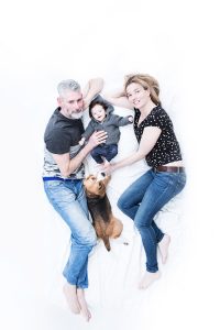 Familie mit Kind und Hund in Aufsicht auf Bett portraitiert © Miriam Ellerbrake