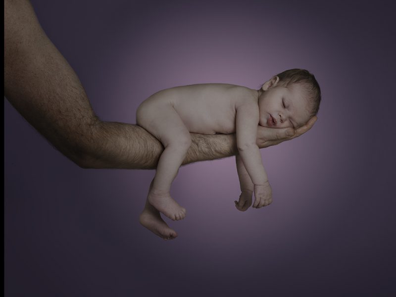 Neugeborenenfoto von schlafendem Baby auf Arm